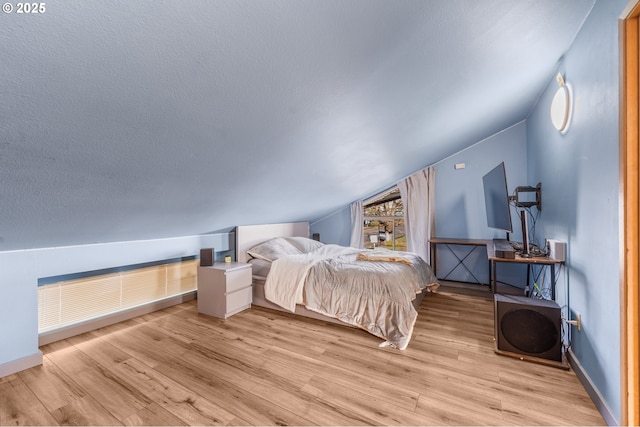 601 N Tomahawk Island Dr, Portland, OR 97217 - bedroom with a textured ceiling, baseboards, vaulted ceiling, and wood finished floors