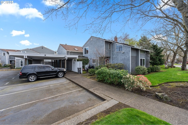 601 N Tomahawk Island Dr, Portland, OR 97217 - view of front of home with a front yard, covered and uncovered parking, and a chimney