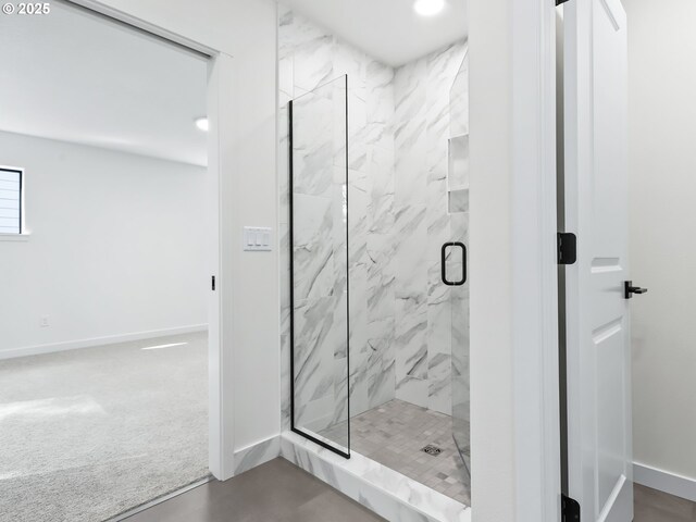 bathroom featuring a marble finish shower and baseboards