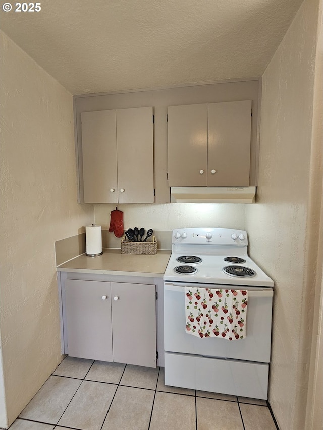 1760 W Broadway, Eugene, OR 97402 - kitchen with electric stove, under cabinet range hood, light countertops, a textured wall, and light tile patterned floors