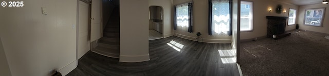 1760 W Broadway, Eugene, OR 97402 - unfurnished room featuring a fireplace, arched walkways, and dark wood-style floors