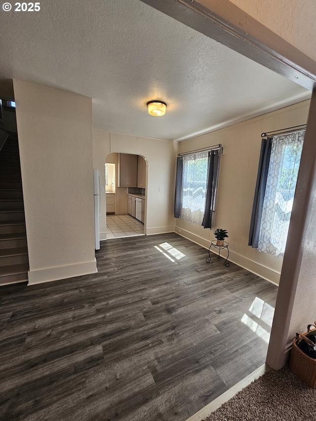 1760 W Broadway, Eugene, OR 97402 - unfurnished living room featuring arched walkways, dark wood-type flooring, a textured ceiling, and stairway