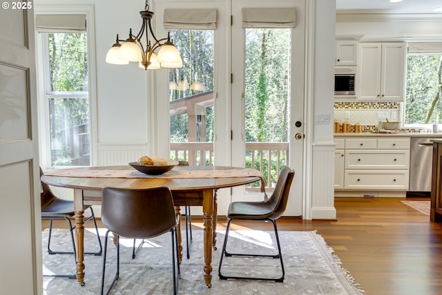 4054 Canal Woods Ct, Lake Oswego, OR 97034 - dining area featuring wood finished floors, a notable chandelier, and a healthy amount of sunlight