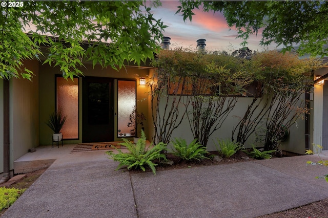 exterior entry at dusk featuring a patio area