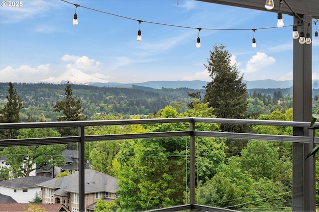 balcony featuring a mountain view and a view of trees