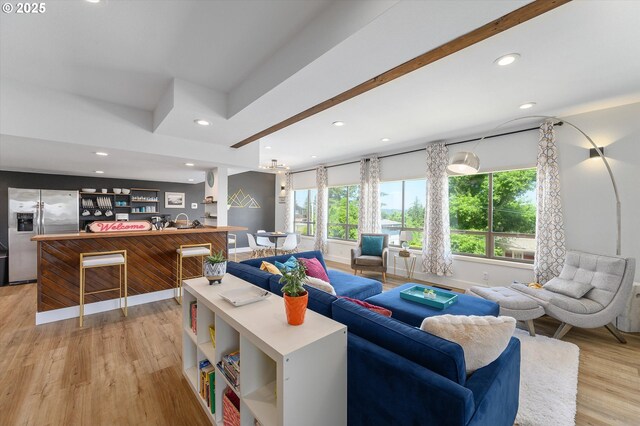 living area with a healthy amount of sunlight, light wood-style floors, baseboards, and recessed lighting