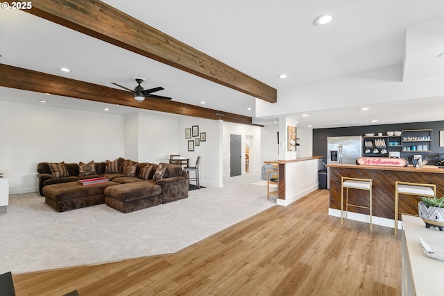 living area with recessed lighting, light carpet, a ceiling fan, baseboards, and beamed ceiling