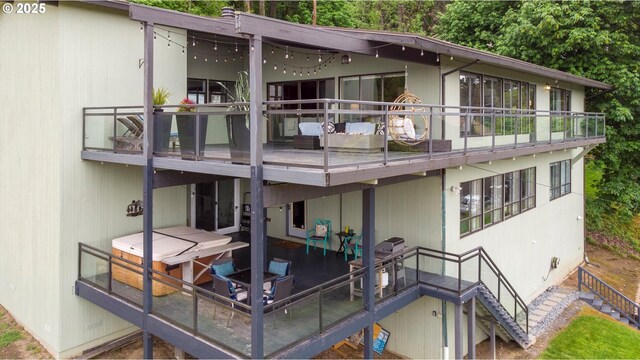 back of property featuring a balcony and stairs