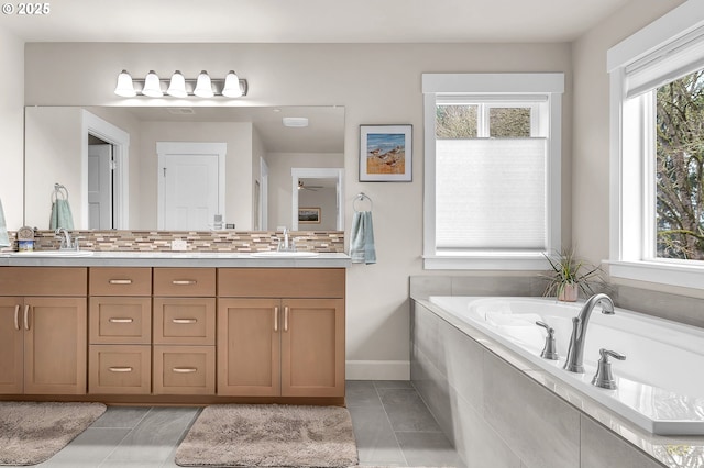 bathroom featuring double vanity, tile patterned floors, a garden tub, and a sink