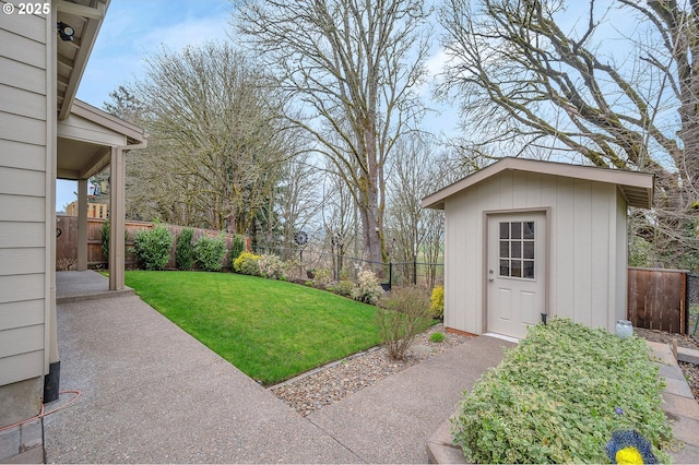 view of yard with an outdoor structure, a fenced backyard, a shed, and a patio