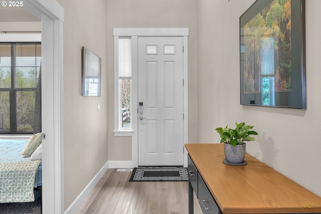 foyer entrance featuring baseboards and wood finished floors