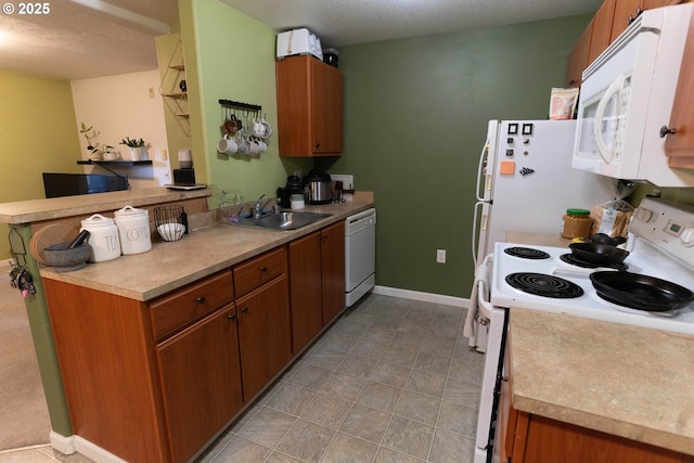 kitchen with sink, white appliances, and kitchen peninsula