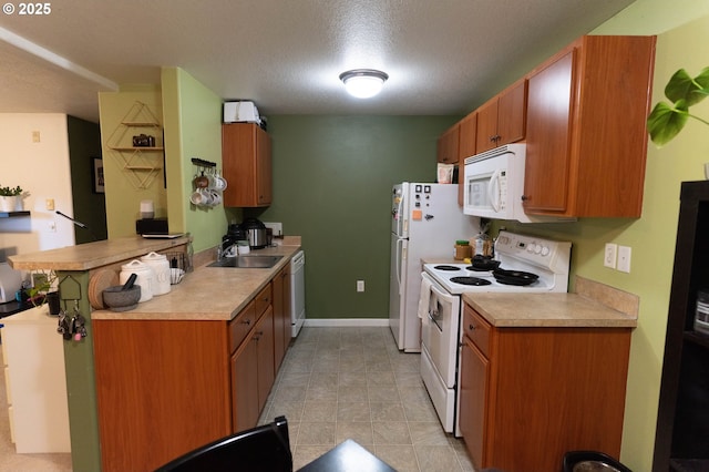 kitchen with white appliances, sink, and a textured ceiling