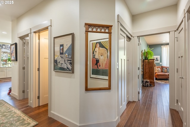 hall featuring baseboards and dark wood finished floors
