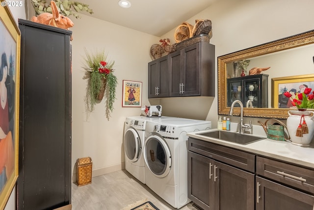 laundry room with a sink, cabinet space, recessed lighting, washer and dryer, and baseboards