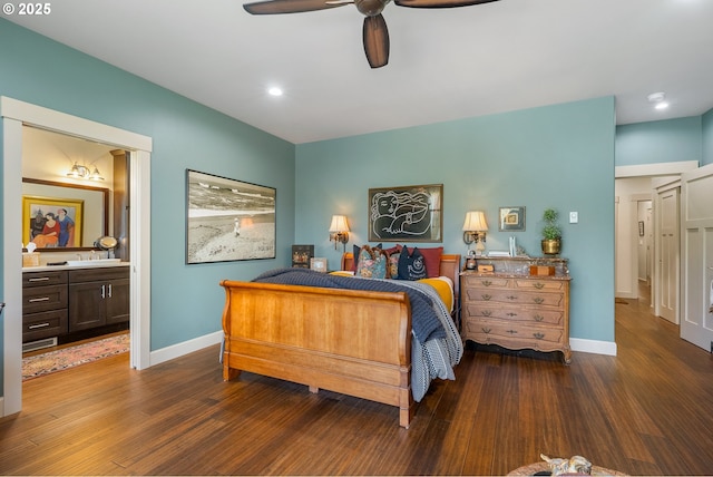 bedroom with ceiling fan, connected bathroom, baseboards, and wood finished floors