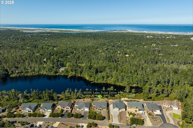 aerial view with a wooded view, a water view, and a residential view