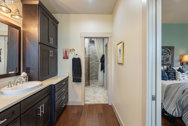 bathroom with vanity, ensuite bathroom, baseboards, and wood finished floors