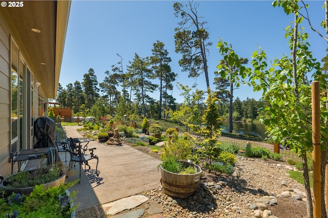 view of patio / terrace with a water view and fence