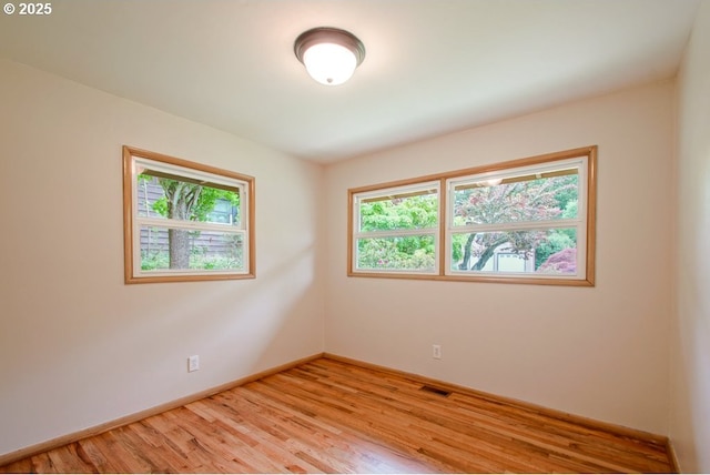 empty room with light wood-style flooring and baseboards