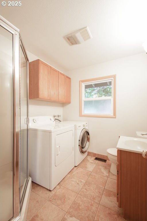 laundry room with washer and dryer and light tile patterned floors