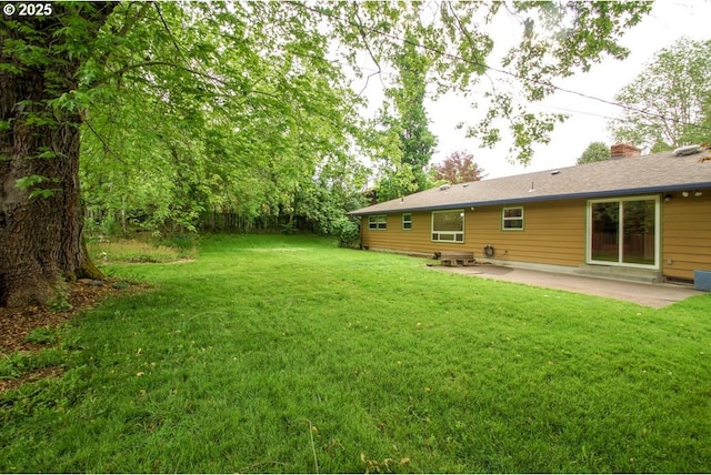 view of grassy yard with a patio and central AC unit