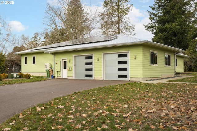 view of front facade with a garage and solar panels