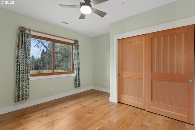 unfurnished bedroom with visible vents, baseboards, light wood-style flooring, ceiling fan, and a closet