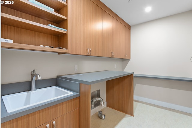 washroom with a sink and baseboards