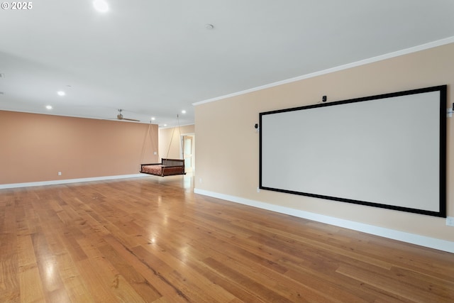 cinema featuring ceiling fan, recessed lighting, baseboards, light wood-type flooring, and crown molding