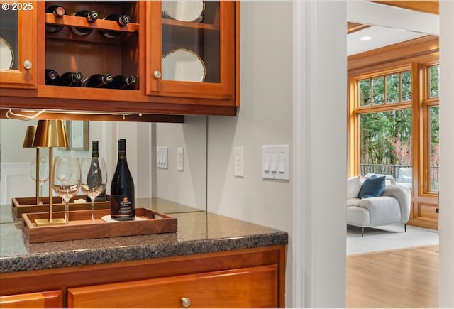 kitchen with open shelves, black appliances, a center island, light wood finished floors, and dark countertops
