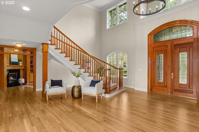 home office featuring wood walls, crown molding, light wood finished floors, a premium fireplace, and coffered ceiling