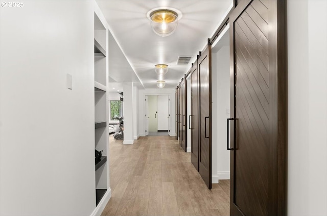 9440 NW Lightning Ridge Dr, Portland, OR 97229 - corridor featuring a barn door, light wood-style flooring, and baseboards
