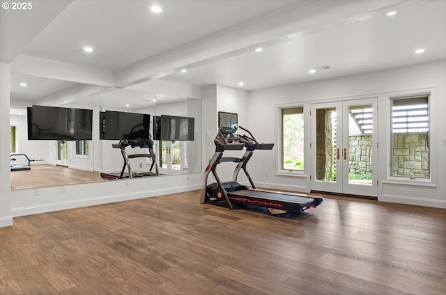 hallway with a barn door, light wood-style floors, and baseboards