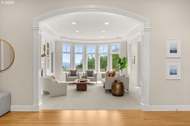 carpeted living room with crown molding, a fireplace, built in shelves, and recessed lighting