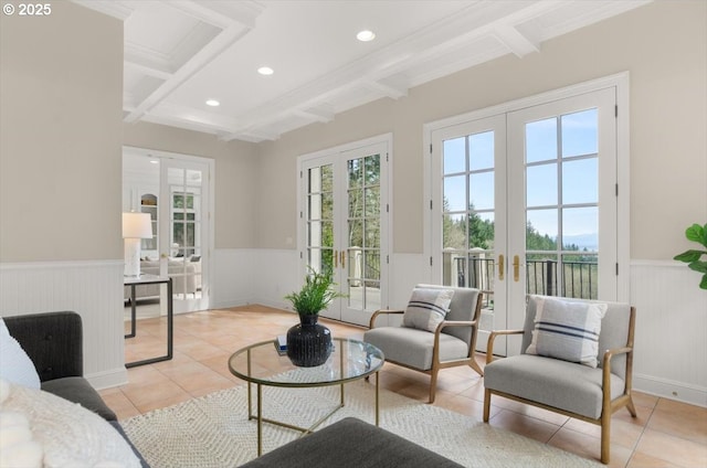 living room with french doors, beam ceiling, light tile patterned floors, coffered ceiling, and wainscoting