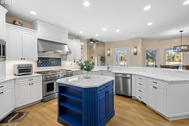 kitchen featuring a center island, stainless steel appliances, white cabinetry, a peninsula, and under cabinet range hood