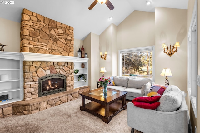 living room featuring built in features, high vaulted ceiling, a ceiling fan, and a stone fireplace