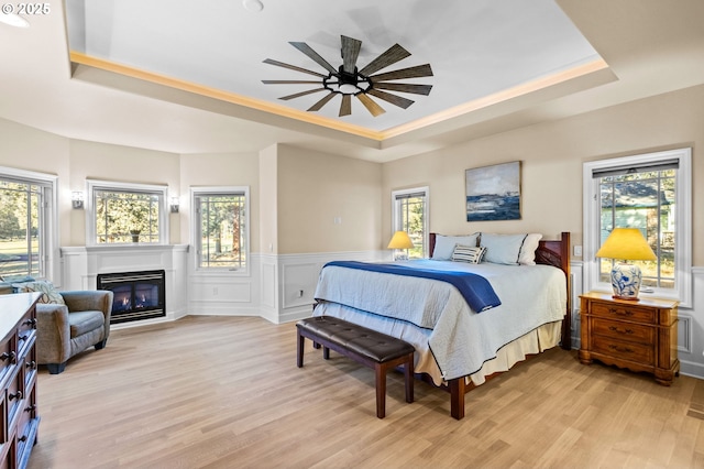 bedroom featuring multiple windows and a raised ceiling