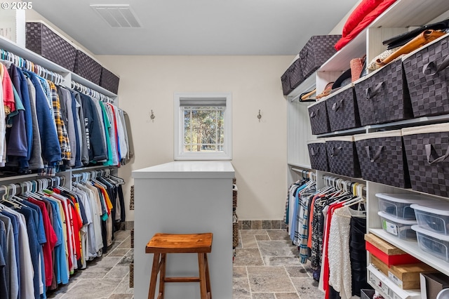 spacious closet with visible vents and stone tile flooring