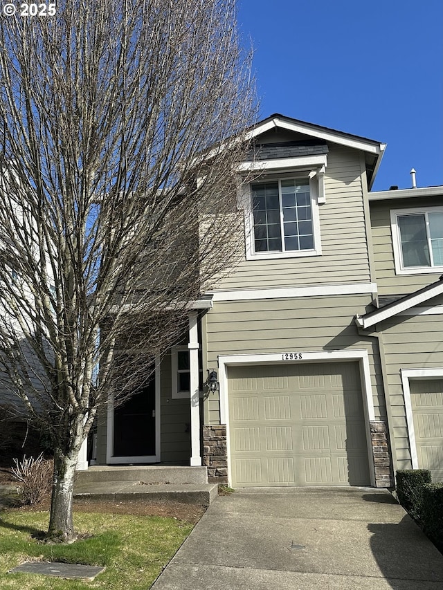 view of front of house featuring an attached garage, stone siding, and driveway