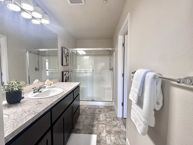 bathroom with a shower stall, baseboards, and vanity