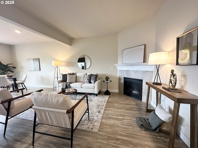 12958 SE 156th Ave, Happy Valley, OR 97086 - living area featuring wood finished floors, a tiled fireplace, baseboards, and beam ceiling