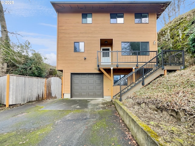 view of front of home featuring aphalt driveway, an attached garage, and stairs