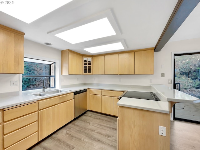 kitchen with light brown cabinets, a peninsula, a sink, light wood-style floors, and stainless steel dishwasher