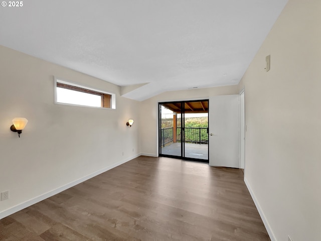 spare room with baseboards, a wealth of natural light, and wood finished floors