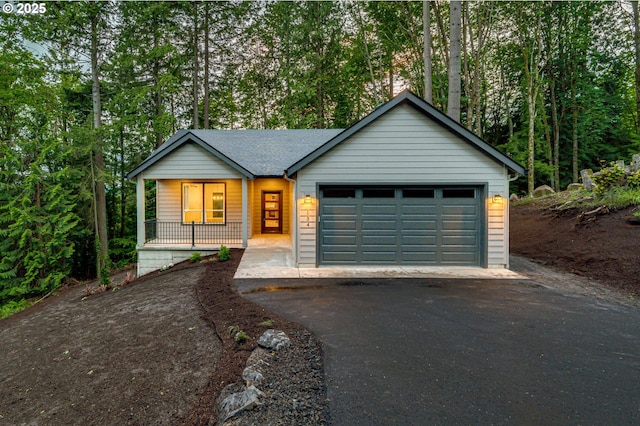 view of front of house with covered porch, driveway, and an attached garage