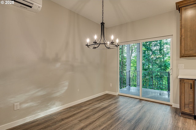 unfurnished dining area with a chandelier, dark wood finished floors, a wall mounted air conditioner, and baseboards