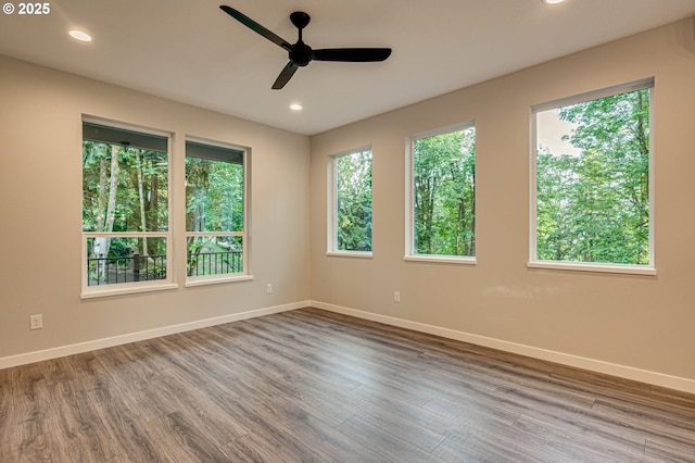 empty room featuring ceiling fan, baseboards, dark wood-style floors, and recessed lighting