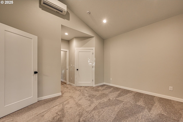 carpeted empty room with an AC wall unit, baseboards, recessed lighting, and vaulted ceiling